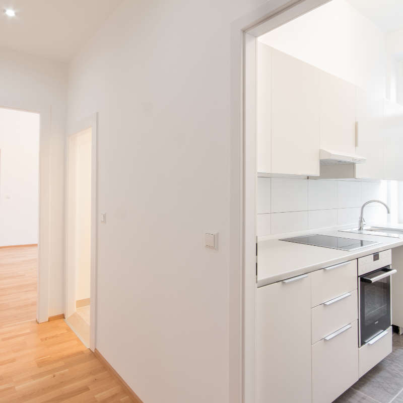 Das Bild zeigt eine helle 3-Zimmer-Wohnung mit Blick in Flur und Küche